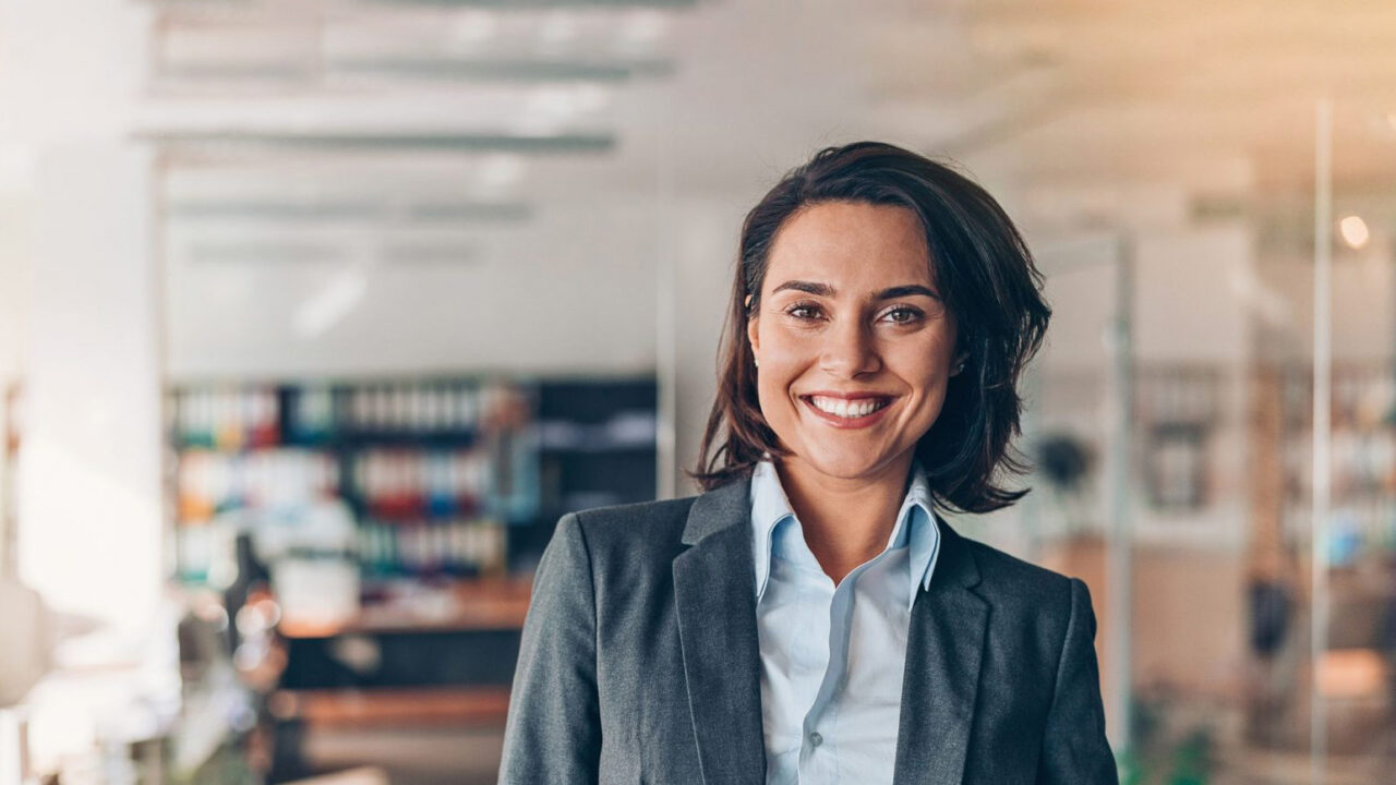 Professional businesswoman smiling at camera in office