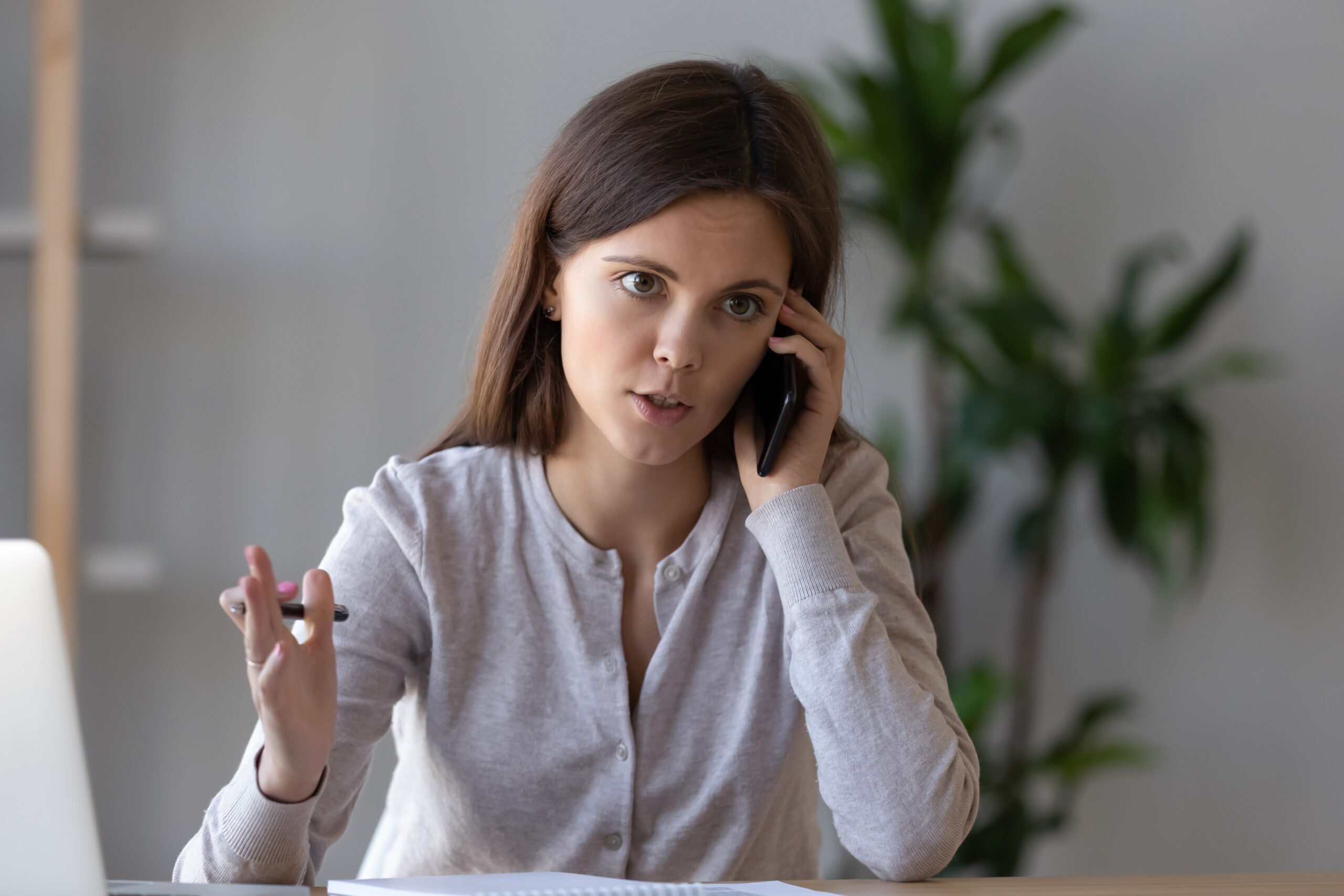 Serious focused manager consulting client talking on the phone making business call at work, young female worker or customer speaking by mobile complaining on service or explaining solving problem