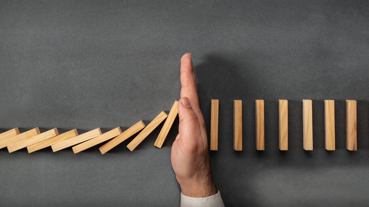 Chain Reaction In Business Concept, Businessman Intervening Dominoes Toppling