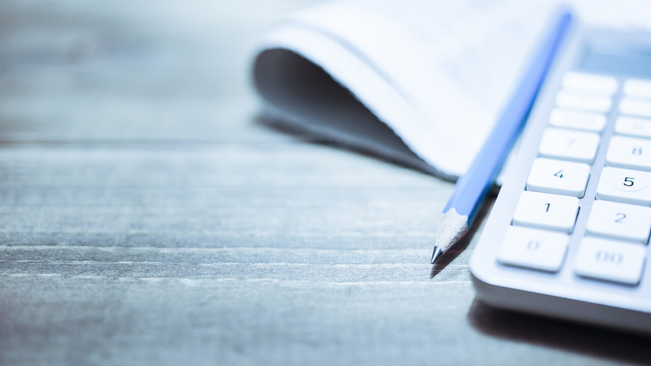 Office supply. Pile of papers paperwork on wooden office desk table. Blue tinted image. Background with copy space. Shot with Nikon D810 ISO64.