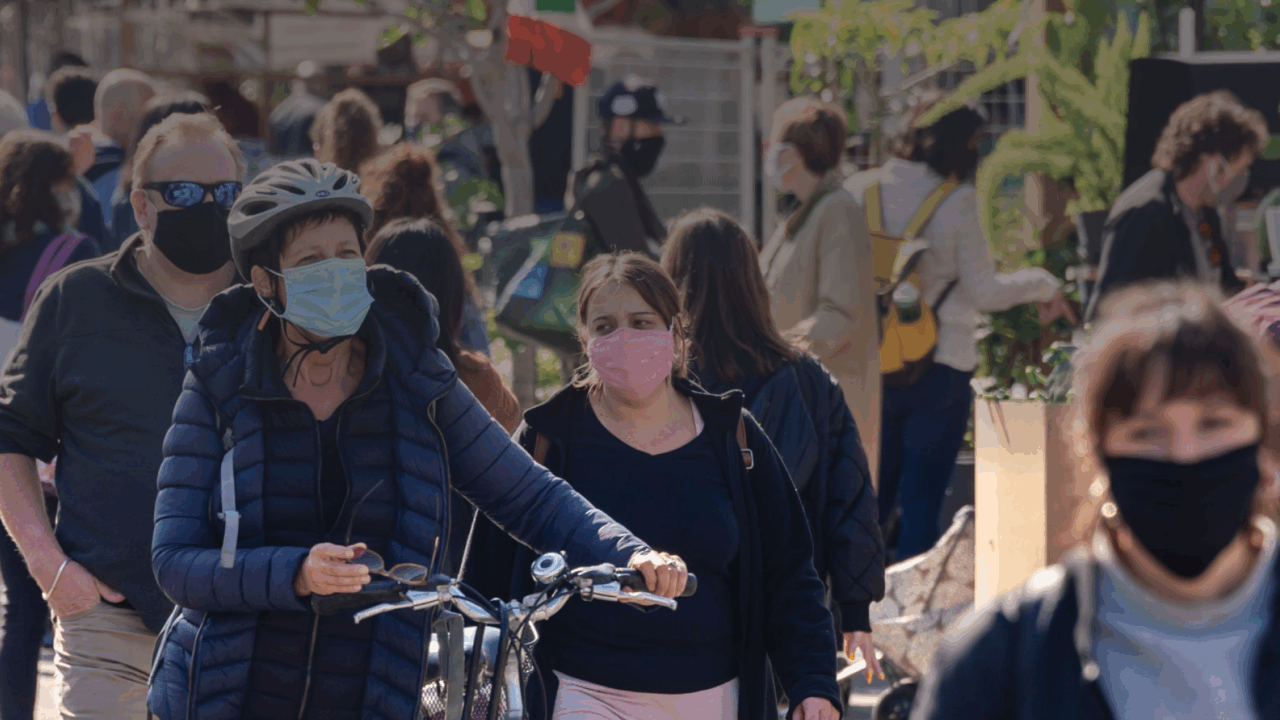 Crowd of people walking with masks on