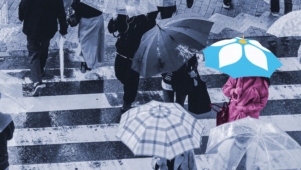 People crossing crosswalk with umbrellas