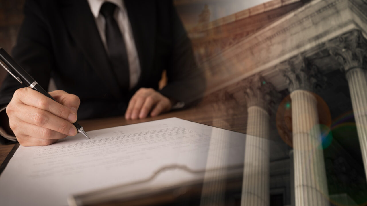 lawyer or attorney signing legal document and agreement with court background. legislation law legal concept