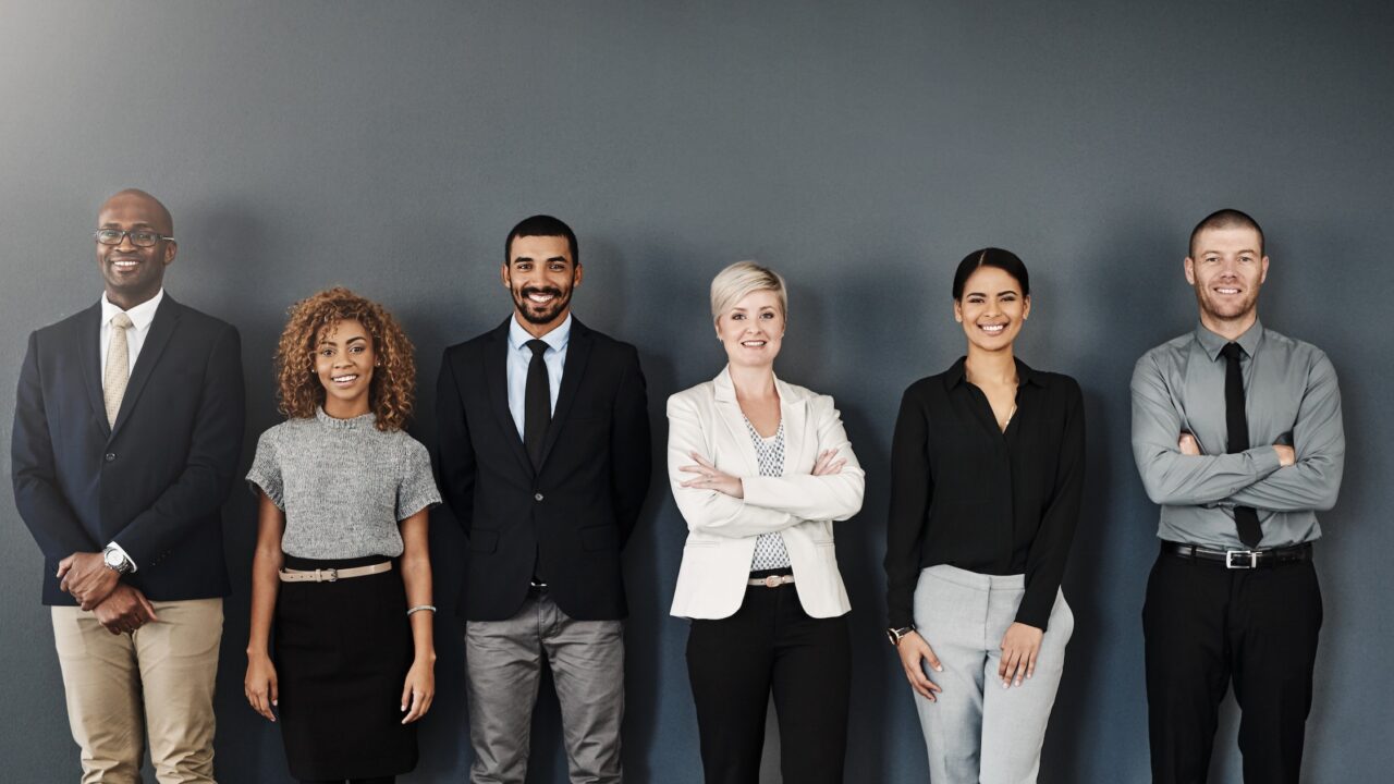 Studio portrait of a group of businesspeople posing against a dark background