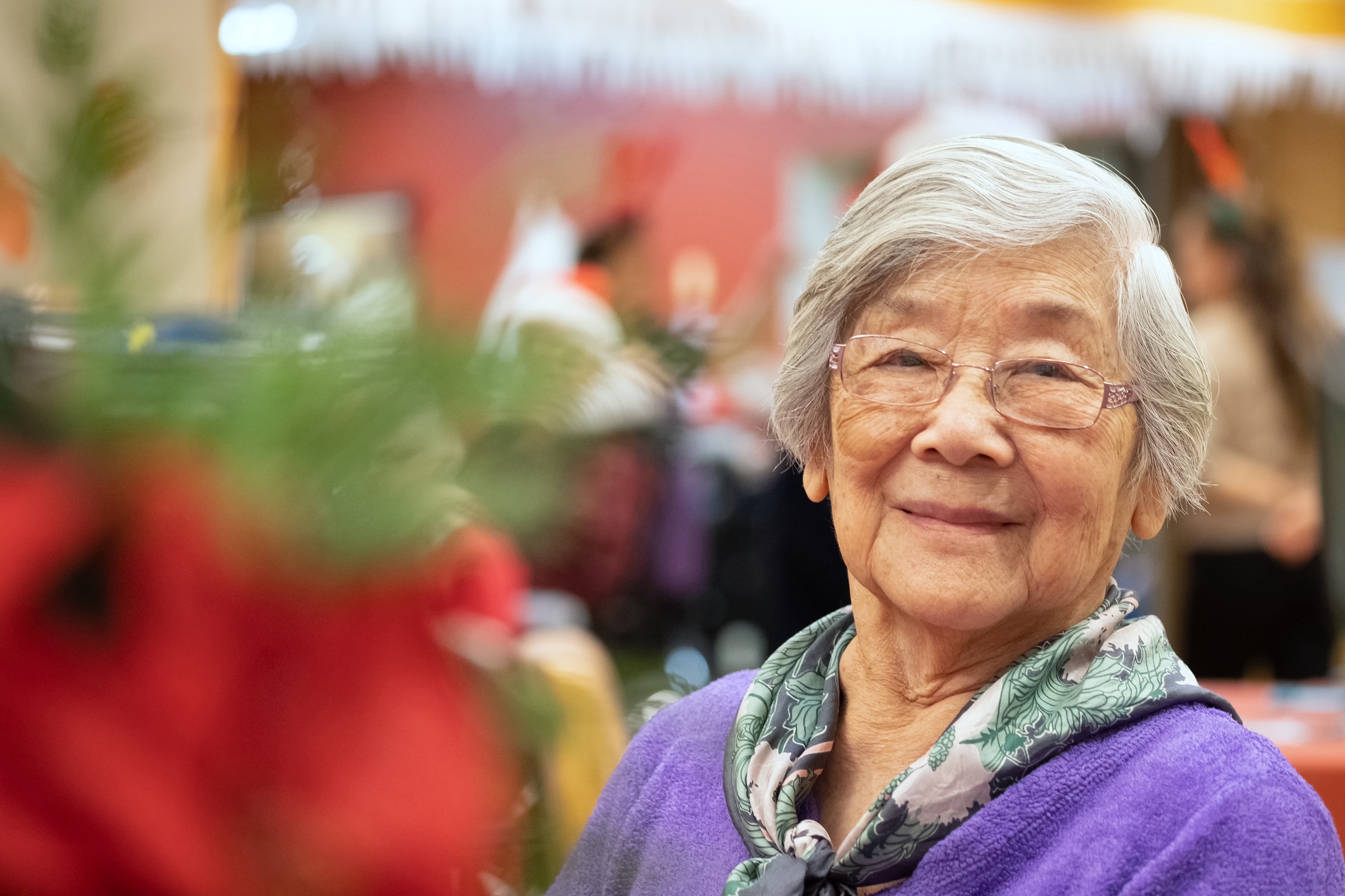 Chinese woman in her 90s enjoying Christmas party. North Vancouver, British Columbia, Canada