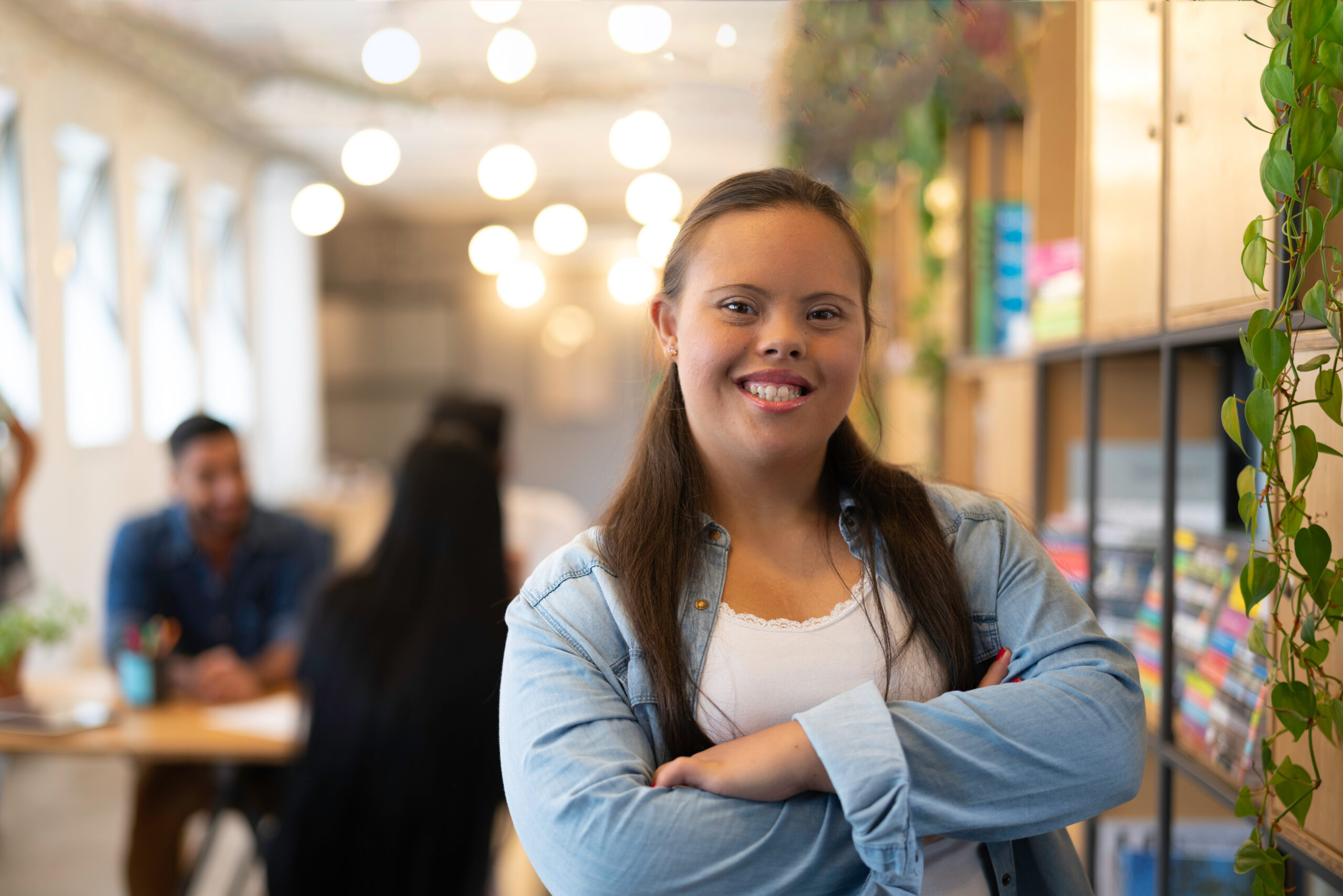 Young woman in a library smiling at the camera.