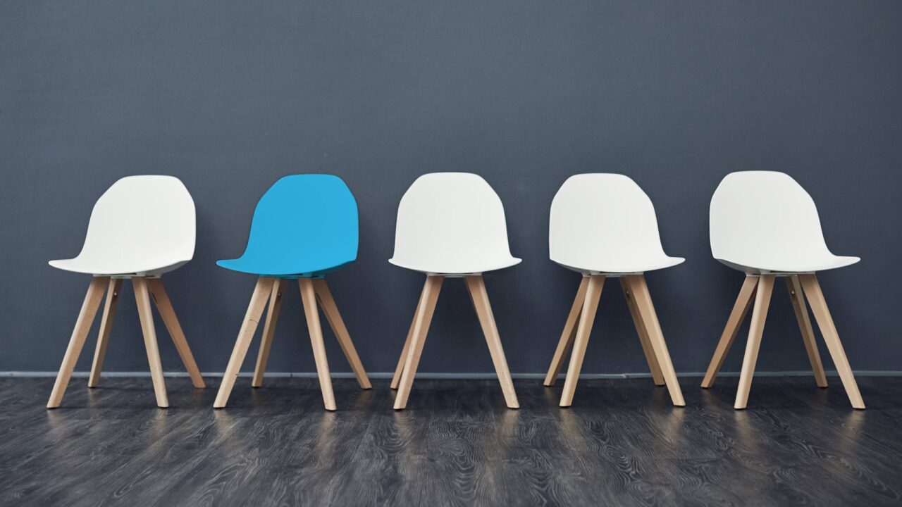 Shot of a row of empty chairs against a grey background inside of a studio